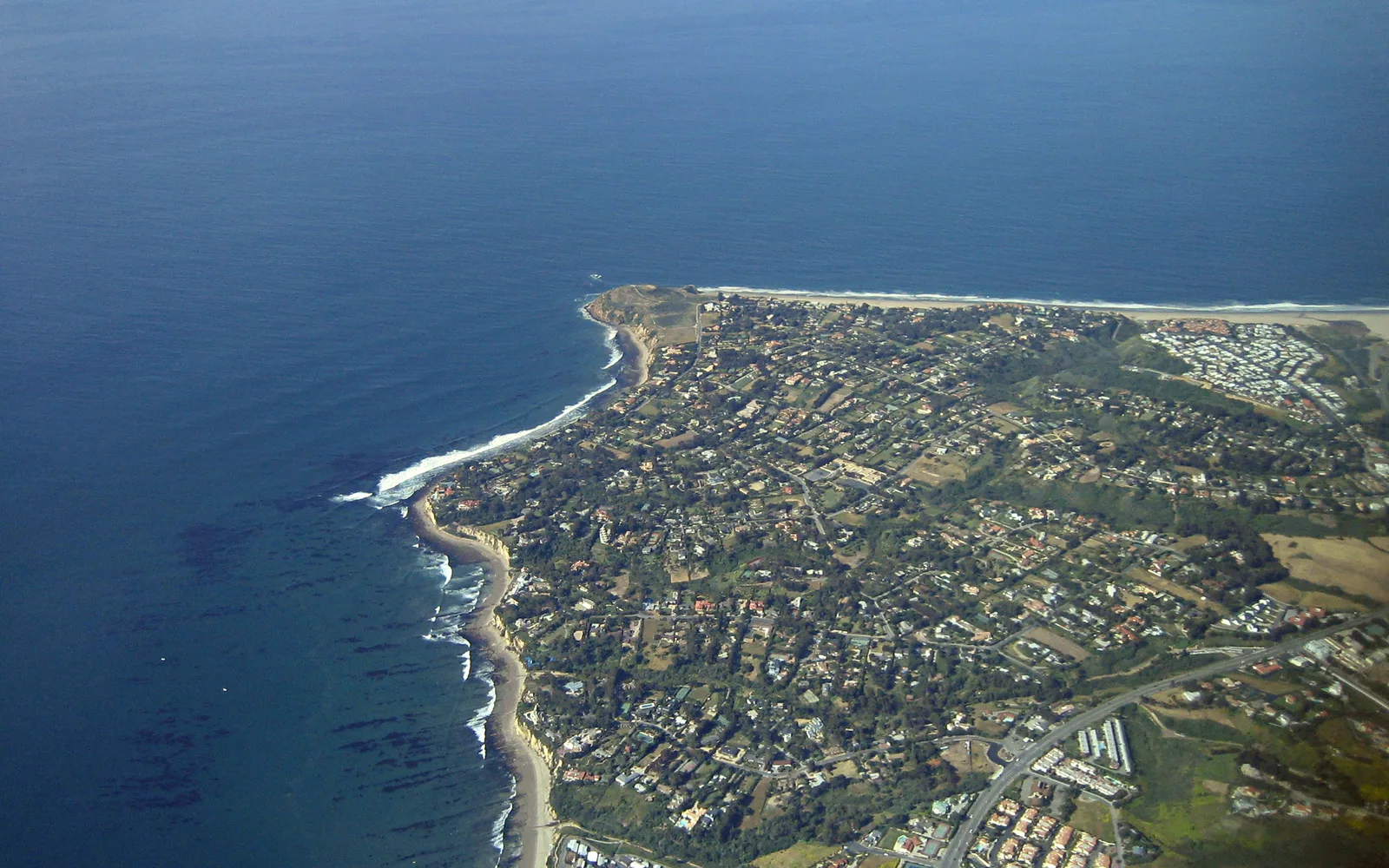 Point Dume coastal headland rising from the Pacific Ocean with vegetation on cliffs